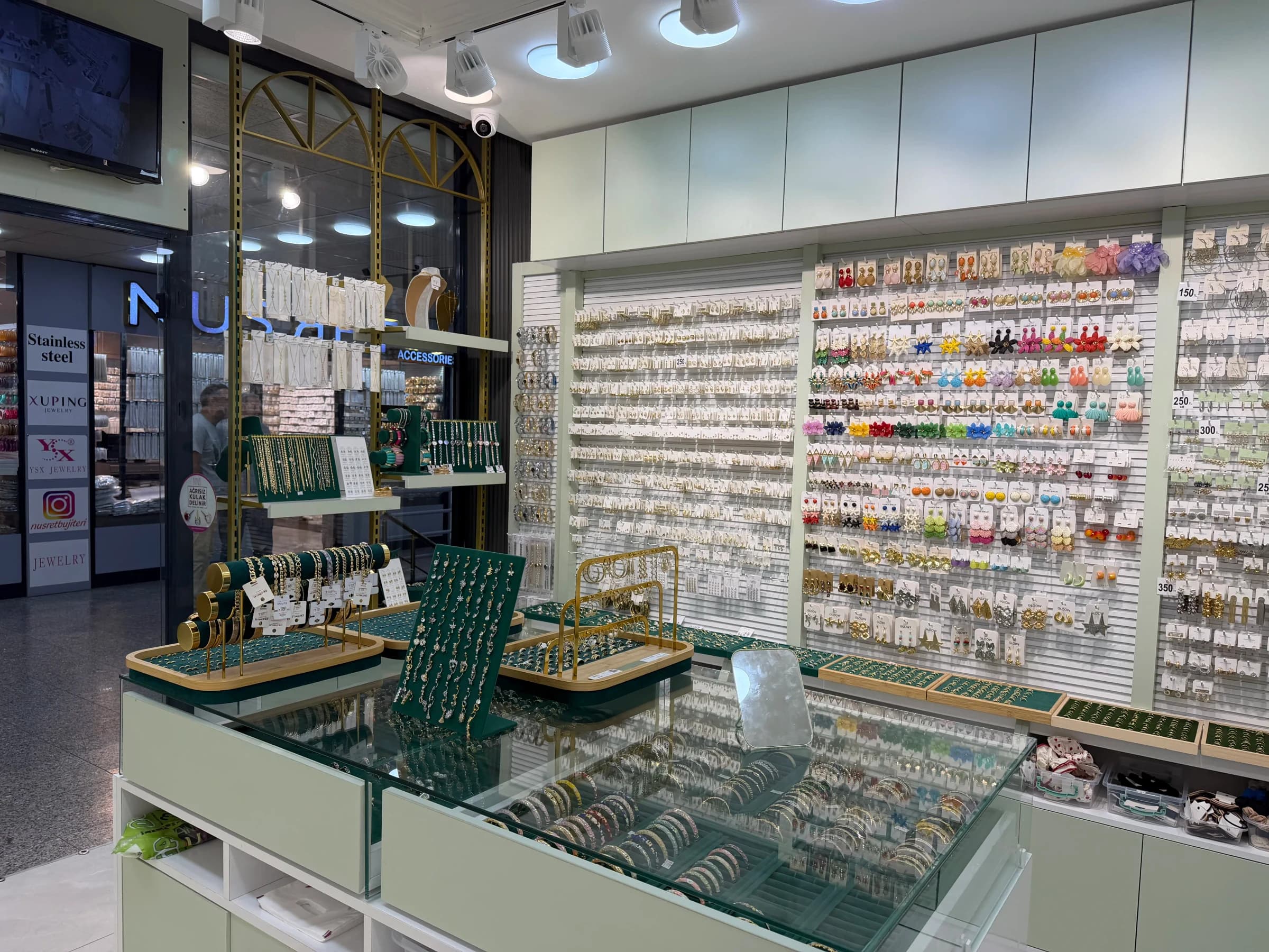 Kare Raf'ın Tahtakale'de kurduğu Roy's Accessories: kanallı pano küpe duvarı ve cam üstlü bilezik tezgâhı